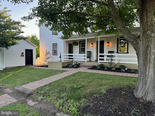 view of front of property featuring covered porch and a front lawn