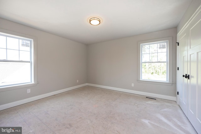 spare room featuring visible vents and baseboards