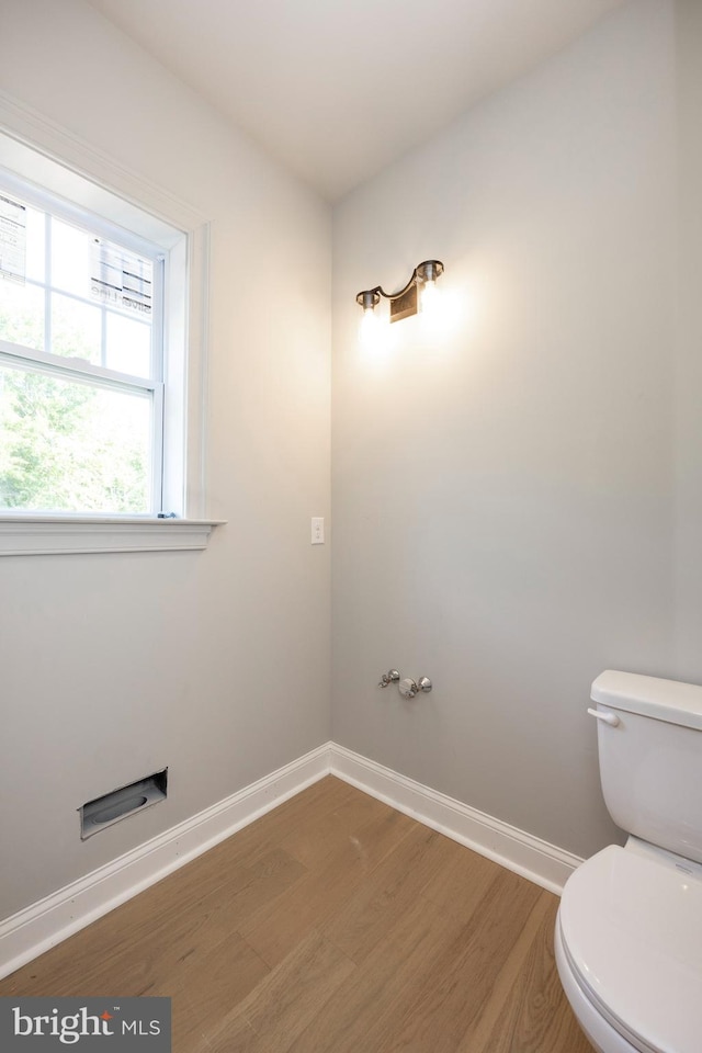 bathroom featuring wood finished floors, toilet, and baseboards