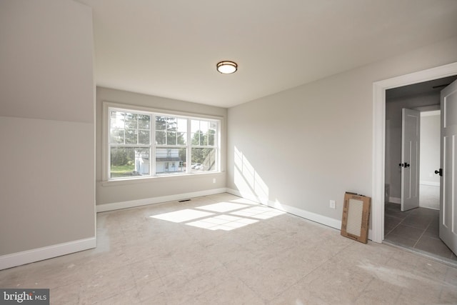 spare room featuring visible vents and baseboards