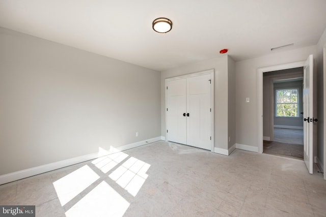 unfurnished bedroom featuring a closet, visible vents, and baseboards