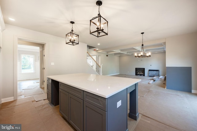 kitchen featuring a center island, pendant lighting, a fireplace, gray cabinets, and light countertops