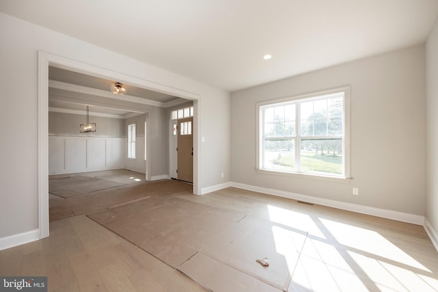 interior space featuring light wood-type flooring, visible vents, and baseboards