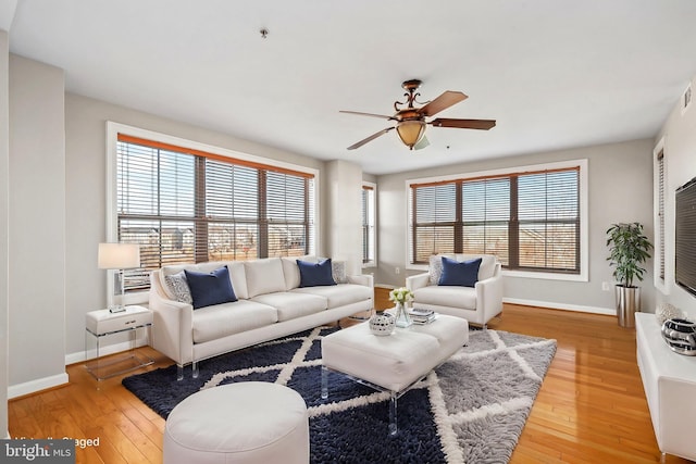 living area with plenty of natural light, wood finished floors, and baseboards