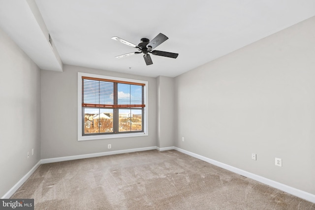 empty room featuring light carpet, ceiling fan, and baseboards