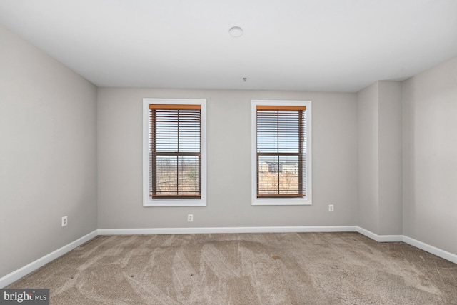 empty room with baseboards and light colored carpet