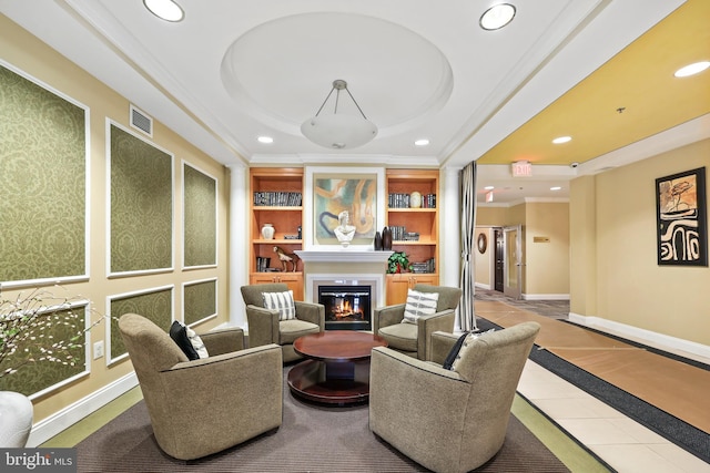 interior space with recessed lighting, visible vents, built in features, ornamental molding, and a glass covered fireplace