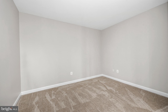 carpeted empty room featuring baseboards