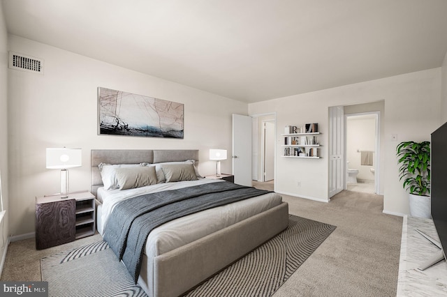 carpeted bedroom featuring ensuite bath