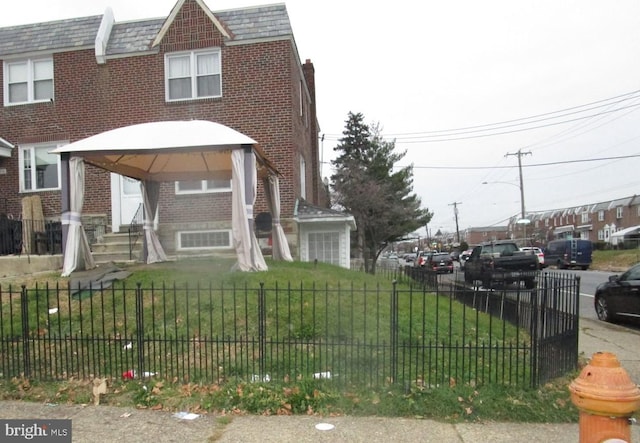 view of front of home with a gazebo and a front lawn