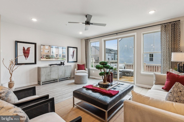 living room with light hardwood / wood-style floors and ceiling fan