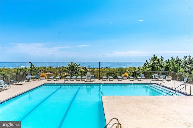 view of swimming pool featuring a water view and a patio area