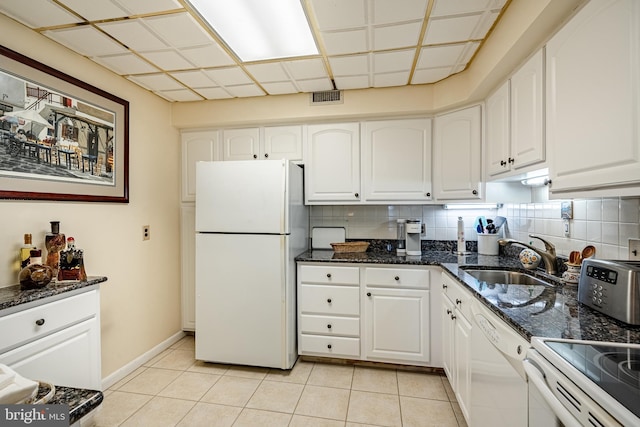 kitchen featuring white appliances, tasteful backsplash, visible vents, white cabinetry, and a sink