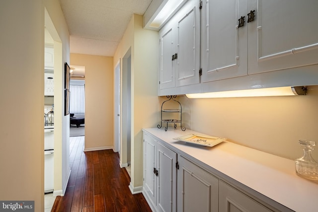 hall with dark wood finished floors and baseboards