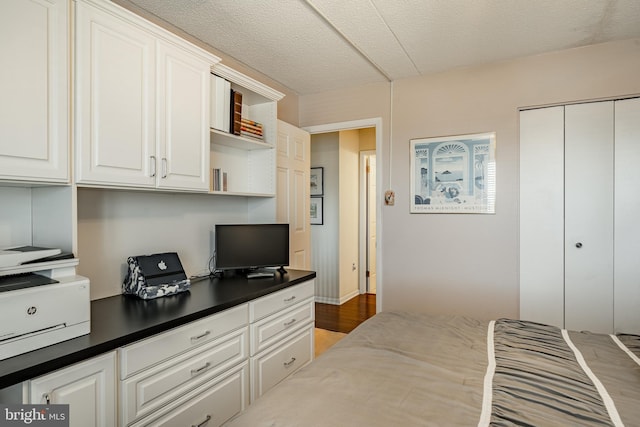 bedroom featuring a textured ceiling, built in desk, and a closet