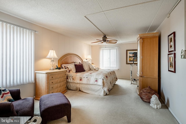 bedroom with a textured ceiling, baseboards, a ceiling fan, and light colored carpet