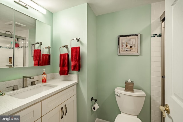 bathroom featuring visible vents, a tile shower, vanity, and toilet