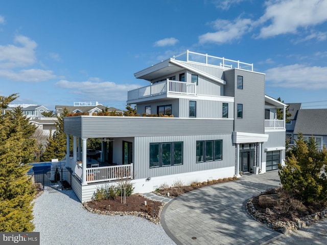 contemporary home with a balcony, a garage, and covered porch