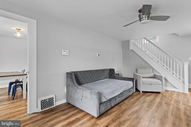 living room featuring hardwood / wood-style floors and ceiling fan