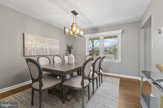 dining room featuring dark wood-type flooring and a chandelier