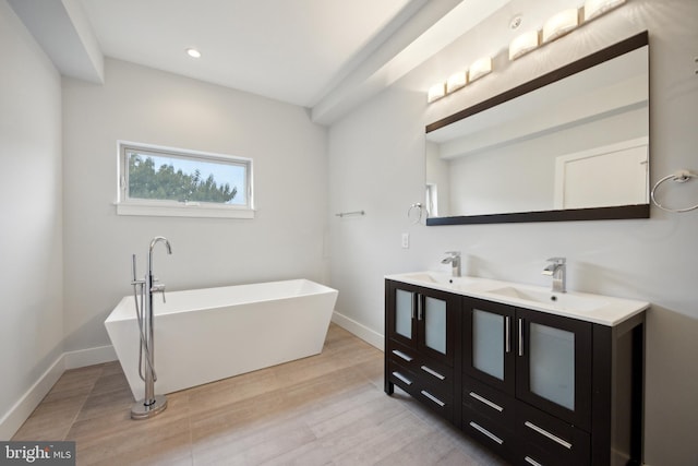 bathroom with a bathing tub, hardwood / wood-style flooring, and vanity