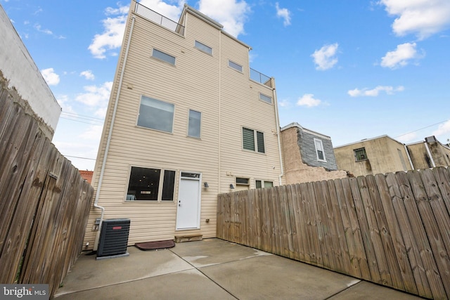 rear view of property with a patio area and cooling unit