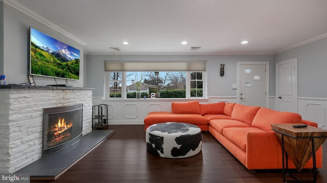 living room featuring crown molding, dark hardwood / wood-style floors, and a fireplace