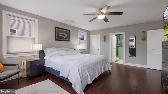 bedroom featuring dark hardwood / wood-style floors, ceiling fan, and ensuite bath