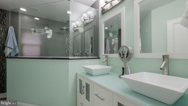 bathroom with vanity and tiled shower