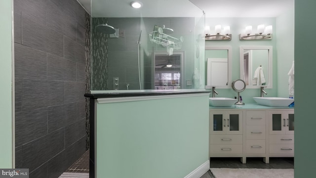 bathroom featuring tile patterned flooring, vanity, and tiled shower