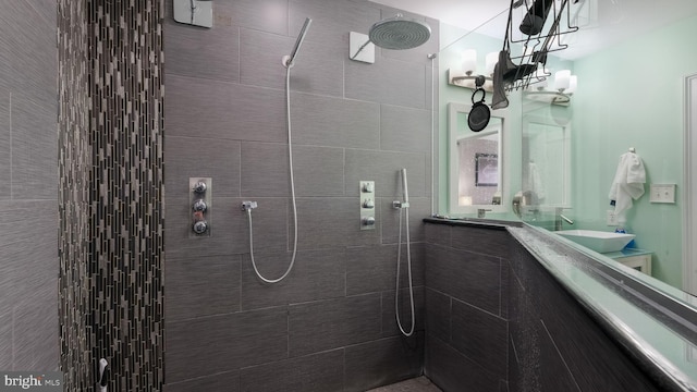 bathroom featuring tiled shower and sink