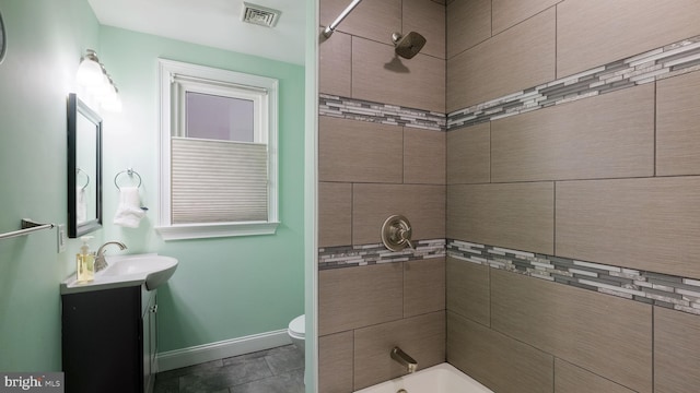 full bathroom with vanity, toilet, and tiled shower / bath combo