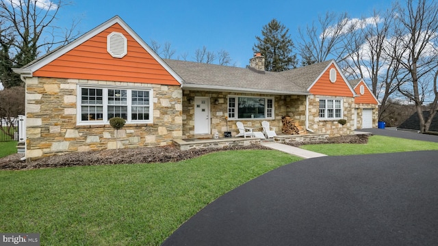 view of front of house with a garage, a front yard, and a porch