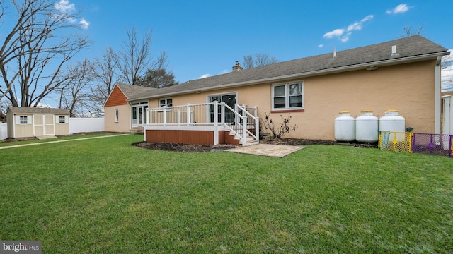 back of house with a wooden deck, a storage shed, and a yard