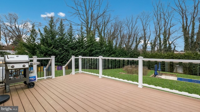 wooden deck with area for grilling and a yard