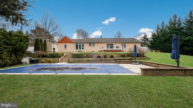 back of house with a yard, a covered pool, and a patio area