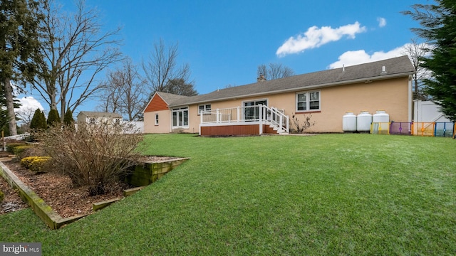 rear view of house with a wooden deck and a yard