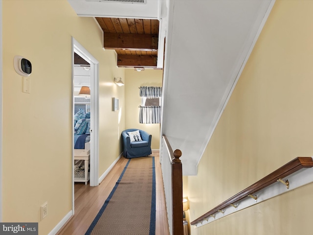 hall featuring light wood-type flooring, beamed ceiling, and wood ceiling