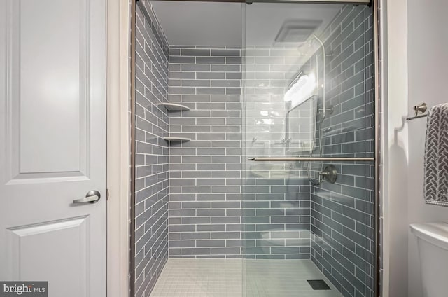 bathroom with toilet and an enclosed shower