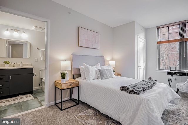 bedroom with light colored carpet, sink, and ensuite bath