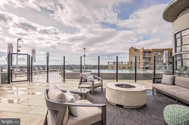 view of patio with an outdoor living space with a fire pit