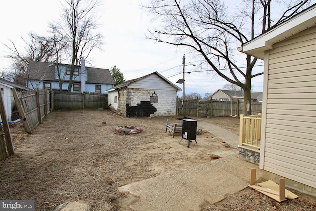 view of yard with a fire pit and an outdoor structure