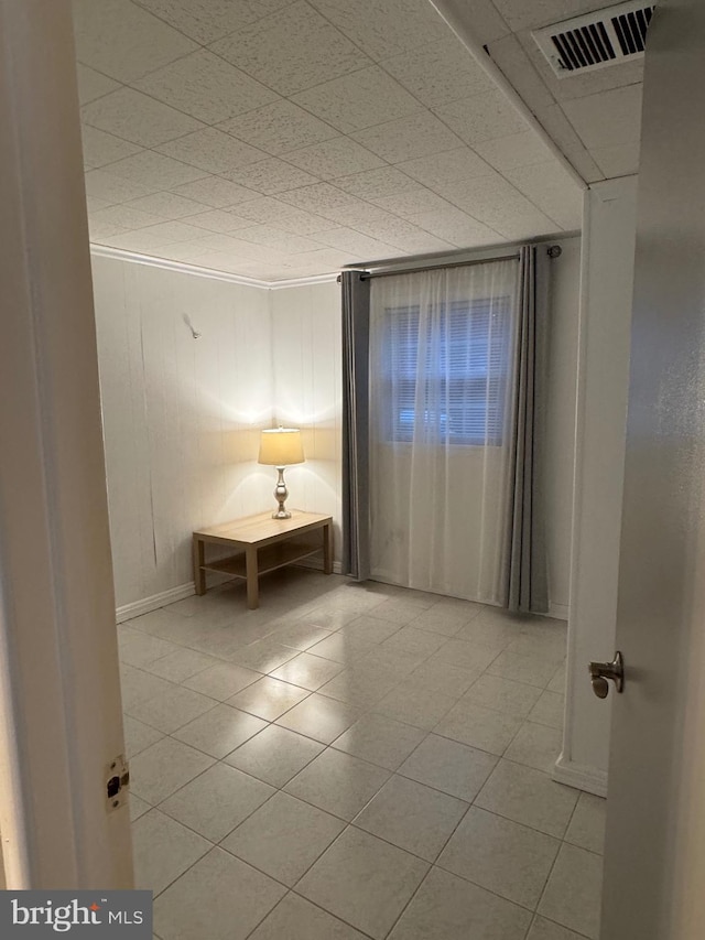 empty room featuring light tile patterned flooring and ornamental molding