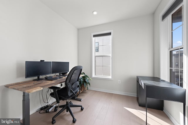 home office with light hardwood / wood-style flooring