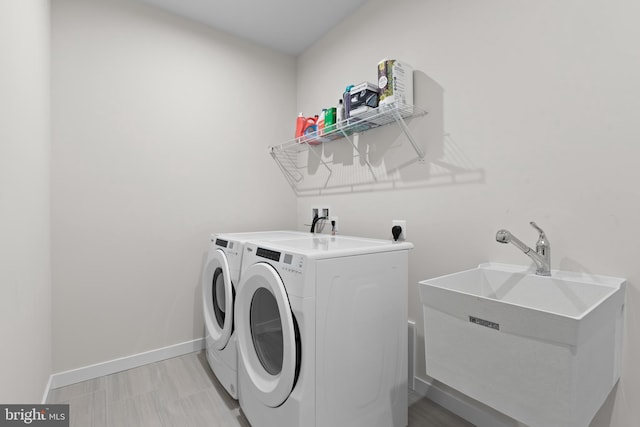 clothes washing area featuring sink and washer and dryer