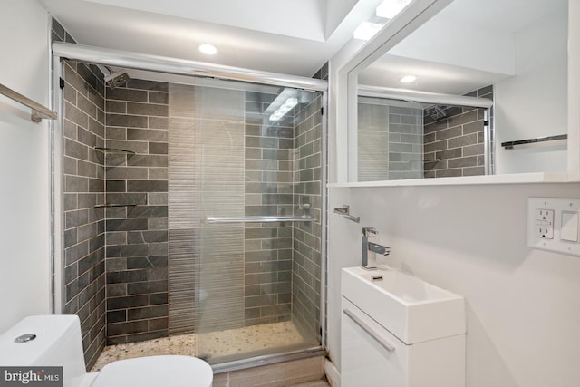 bathroom with a shower with shower door and toilet