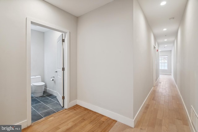 hallway with hardwood / wood-style floors