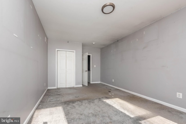 unfurnished bedroom featuring concrete floors and a closet