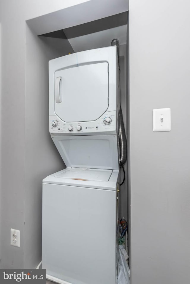 washroom featuring stacked washer / drying machine