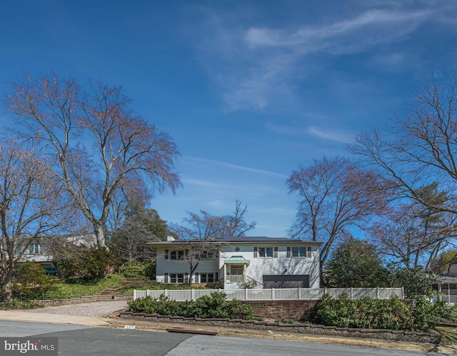 bi-level home featuring a fenced front yard and stucco siding